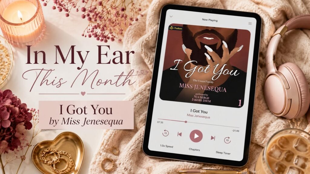 Cozy audiobook flat lay featuring blush headphones, iced coffee, a glowing candle, flowers, gold jewelry, and a tablet displaying I Got You by Miss Jenesequa, with the text “In My Ear This Month.”
